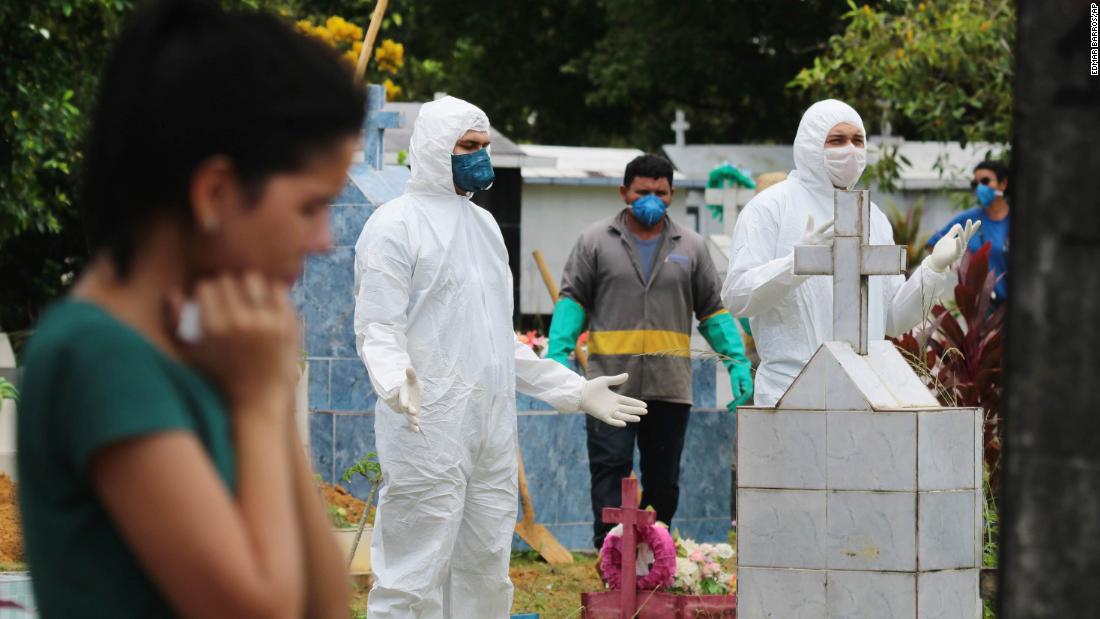 People pray next to the grave of musician Robson de Souza Lopes after his burial in Manaus, Brazil, on March 31. According to authorities at the Amazonas Health Secretary, the 43-year-old died after being diagnosed with the novel coronavirus.